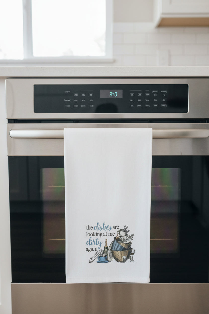 Kitchen towel with humorous design and text hanging on a rack.