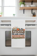 Kitchen towel with decorative text and graphics on a black surface
