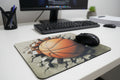 Mouse pad with a basketball design and a computer mouse on top